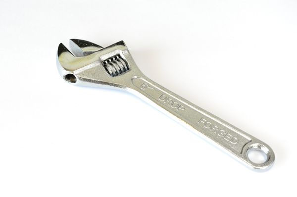 A photo of an adjustable wrench on a white background